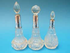Three hallmarked silver mounted cut glass scent bottles with stoppers