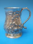 A George III Irish provincial silver tankard of baluster form with embossed decoration,