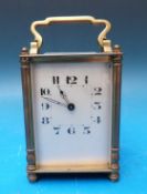 A mid 20th century brass carriage clock with Arabic numerals and a painted dial with 'skeleton