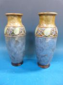 A pair of Royal Doulton vases decorated with flowers,