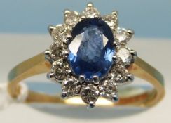 An 18ct gold ring set with a central oval topaz surrounded by diamonds (size O)