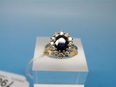 An 18ct gold ring set with an oval cut sapphire surrounded by diamonds (size L)