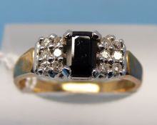 A 9ct gold ring set with an emerald cut sapphire and six diamonds to each shoulder (size N)