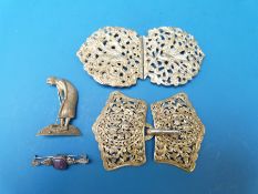 A hallmarked silver belt buckle (London 1972) decorated with birds, a white metal belt buckle,