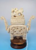 A Chinese carved ivory snuff bottle with carved dragon decoration and claw feet on a wooden base