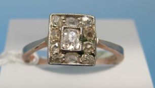 A yellow metal ring set with old cut diamonds in a rectangular setting around a centre stone (size