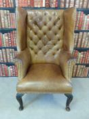 A late 19thC leather Chesterfield wing back armchair