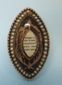 A Georgian mourning brooch decorated with hair with gold decoration and a small bone section to the