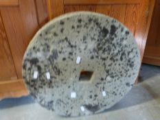 A stone millstone, approximately 46.5cm in diameter and 6.5cm deep.