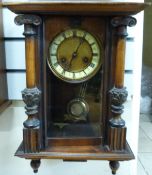 A two train wall clock by Wurttemberg in ornate case with finials to base and carved pillars to