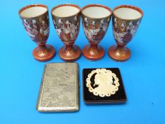 A tribal style carved ivory brooch together with a set of four Oriental egg cups and an Oriental