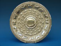 A Burmese white metal tray, profusely embossed with concentric rings of animals including elephants,