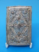 A hinged white metal filigree cigarette case