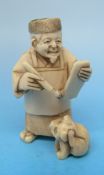 A Japanese ivory netsuke in the form of a scholar with a dog by his left foot