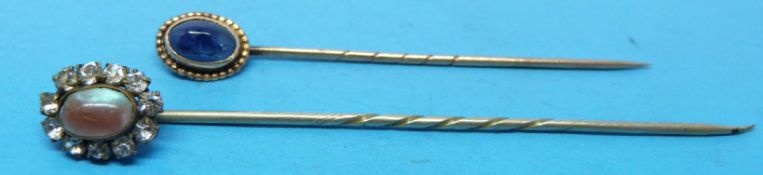 Two yellow metal stick pins,