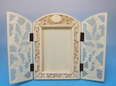 A carved ivory opening picture frame with carved floral decoration