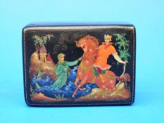 A Russian Palekh lacquer box decorated with a man on horseback,