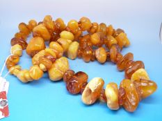 An amber necklace formed of 98 translucent and butterscotch irregularly shaped beads,