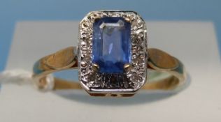A 9ct gold ring set with an emerald cut topaz surrounded by diamonds (size M)