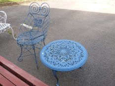 A blue cast garden table and a wirework chair