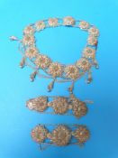 A white metal filigree necklace and two matching bracelets