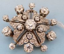 A gold and platinum pendant or brooch set with diamonds in a stylised flower cluster,