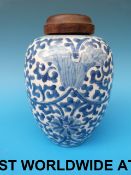 An 18thC Chinese blue and white jar with scrolling floral decoration and fitted wooden top (19.