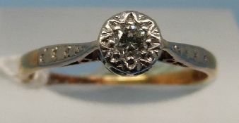 An yellow metal ring marked 18ct and platinum set with a solitaire diamond in an illusion setting