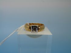 An 18ct gold ring set with a baguette cut diamond in platinum mount (size L)