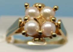 A yellow metal ring set with four pearls