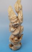 A Japanese ivory okimono of a monkey grappling with an old man with a fan
