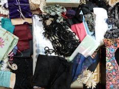 Two trays of vintage textiles including small rolls of silk, mourning belt,