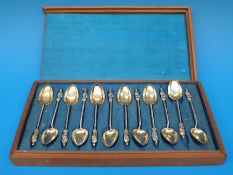 A boxed set of 12 figurehead Chinese white metal teaspoons,