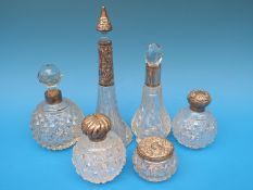 A collection of five cut glass and hallmarked silver mounted scent bottles together with a silver