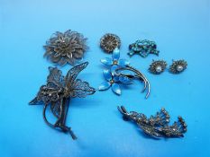 Three filigree white metal brooches of floral design,