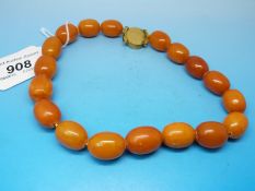 An amber necklace of largely uniform oval beads the largest 2cm and smallest 1.
