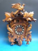 A large Black Forest cuckoo clock with seated man and cuckoo feature
