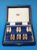 A cased set of his and hers hallmarked silver place settings in the form of ladies and gents shoes,