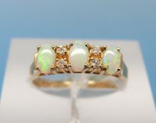 A 14ct gold ring set with three opals and alternating diamonds (size M)