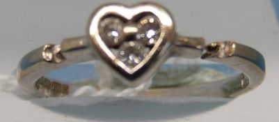 An 18ct white gold ring set with three diamonds in a heart setting (size K)