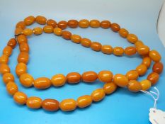 An amber necklace formed of 60 oval egg yolk coloured beads each measuring 1.9cm x 1.
