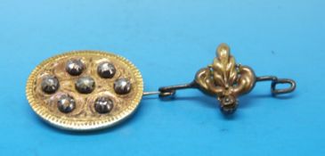 A Victorian/Edwardian brooch set with seven rose cut diamonds and another brooch set with a single
