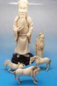 A Chinese ivory carving of a bearded war official, his robe carved with dragons and clouds,