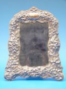 A hallmarked silver photograph frame with floral embossed design in the Art Nouveau style,
