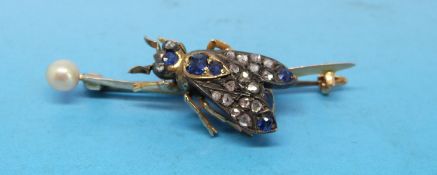 A gold brooch set with a diamond and sapphires in the form of a bee and a pearl to one end