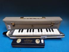 A two octave cased Hohner melodica together with a Lieblinge Hohner 24 holed tremelo harmonica in C