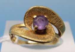 An 18ct gold ring set with an amethyst in a textured twist setting (size L)