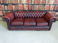 A red leather Chesterfield three seat sofa