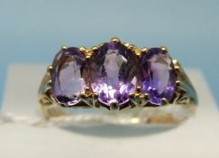 A 9ct gold ring set with three oval cut amethysts (size M)