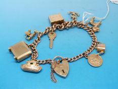 A 9ct gold charm bracelet with nine charms to include an anchor, poodle, clock,